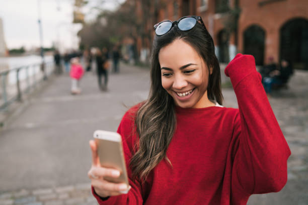 istock Woman holding phone with successful expression. 1271155968