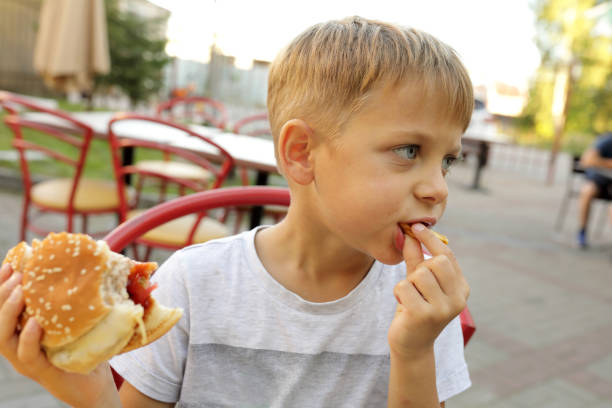 istock Child eating fries and burger 1271160963