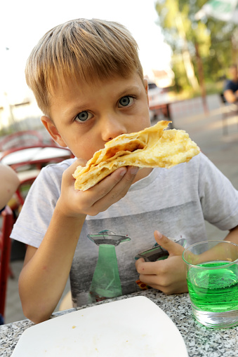 Child eating Megrelian Khachapuri in georgian restaurant