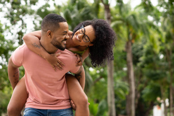 beau couple afro ayant l’amusement dans le parc - attractive couple photos et images de collection