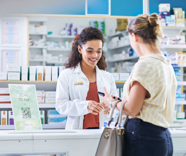 From diagnosing to dispensing, she does it all Shot of a young pharmacist assisting a customer in a chemist chemist stock pictures, royalty-free photos & images