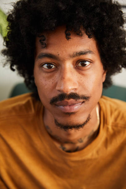 istock Young man with neck tattoos sitting at home 1271166037