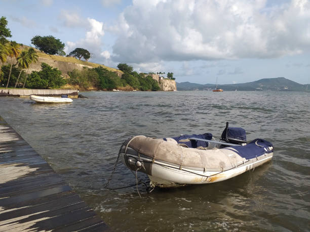 зодиаки или моторные лодки пришвартовылись в бурных серых водах карибского моря после тропического шторма под карибским облачным небом. м� - sailboat pier bridge storm стоковые фото и изображения