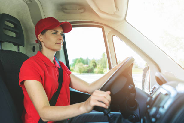 transportation services - young woman in red uniform driving van