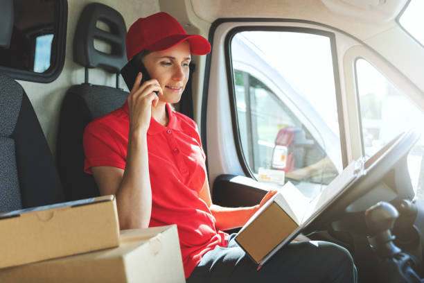 istock delivery woman talking on mobile phone in van 1271168452
