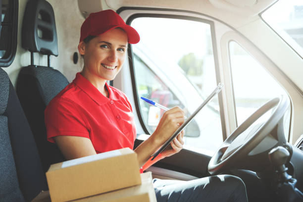 istock young smiling delivery person in red uniform sitting in van and writing documents 1271168453
