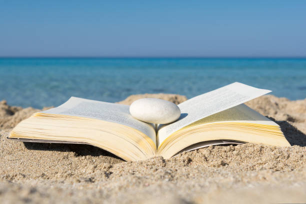 istock Open book on the sand at the beach, close up 1271170613