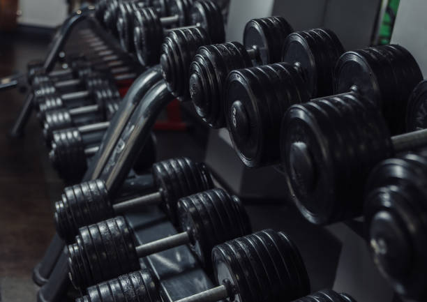 istock Black dumbbells on a rack close-up in the gym 1271171631