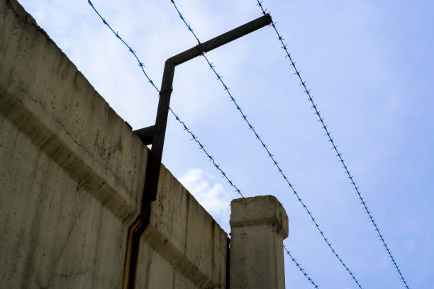 istock concrete fence with barbed wire against the blue sky 1271172712