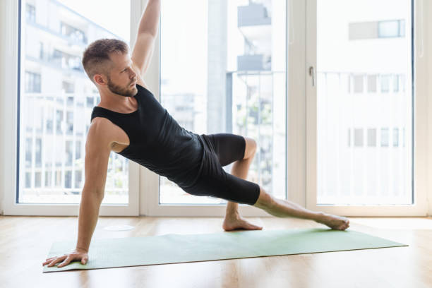 istock Man practicing yoga at his home 1271174400