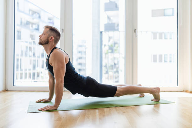 istock Man practicing yoga at his home 1271174459