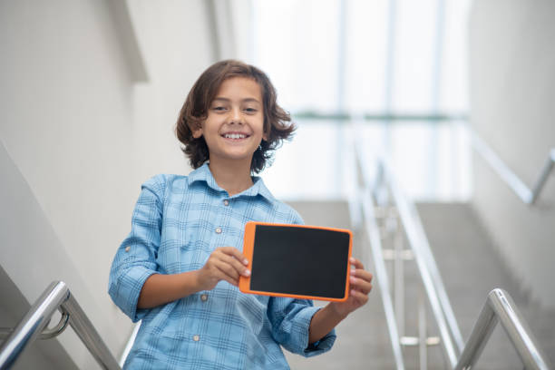 мальчик с планшетом в руках на лестнице - место представляющее интерес стоковые фото и изображения