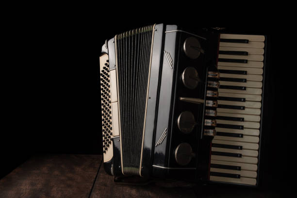 istock Old accordion on rustic wooden surface with black background and Low key lighting, selective focus. 1271180335