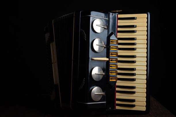 istock Old accordion on rustic wooden surface with black background and Low key lighting, selective focus. 1271180383