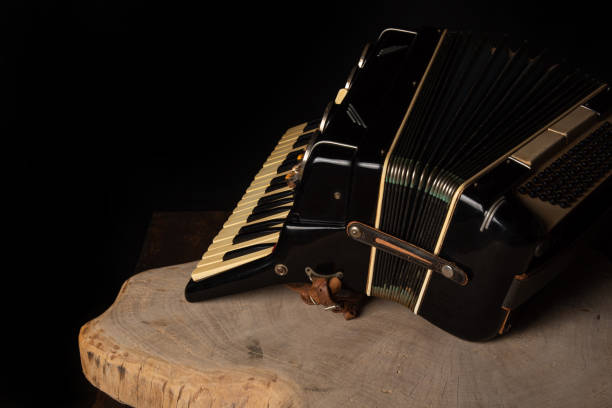 istock Old accordion on rustic wooden surface with black background and Low key lighting, selective focus. 1271180411
