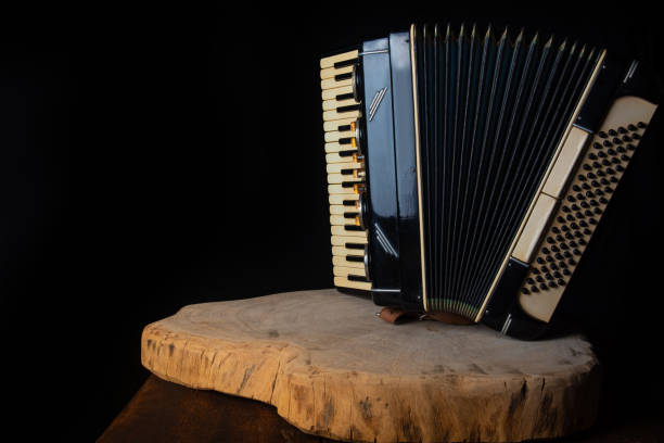 istock Old accordion on rustic wooden surface with black background and Low key lighting, selective focus. 1271180415
