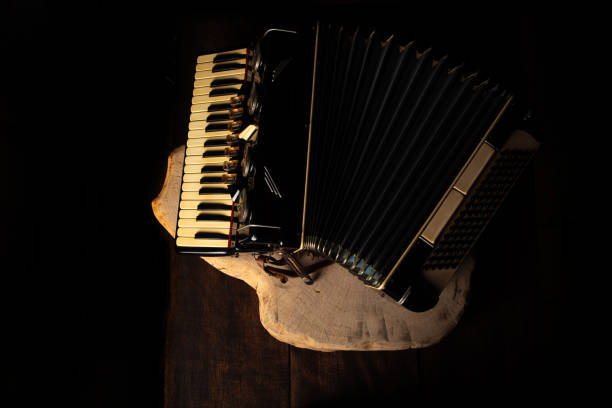 istock Old accordion on rustic wooden surface with black background and Low key lighting, selective focus. 1271180438