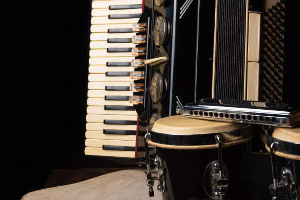istock Old accordion, harmonica and bong on rustic wooden surface with black background and Low key lighting, selective focus. 1271180466