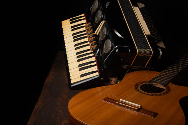 istock Old accordion and a beautiful guitar composing a scene on a rustic wooden surface with black background and low key lighting, selective focus. 1271180516