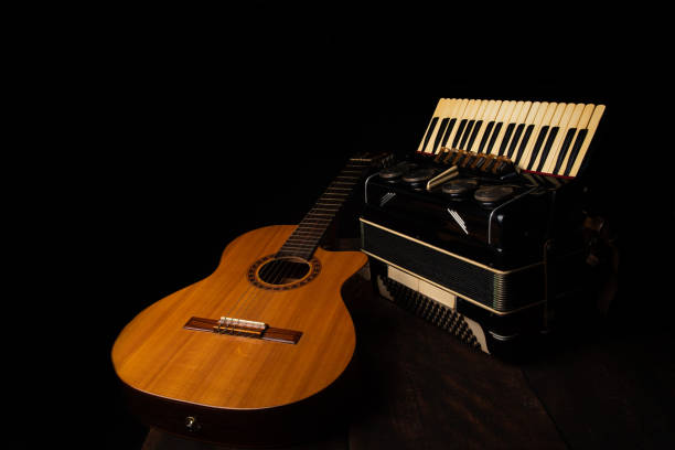 istock Old accordion and a beautiful guitar composing a scene on a rustic wooden surface with black background and low key lighting, selective focus. 1271180534