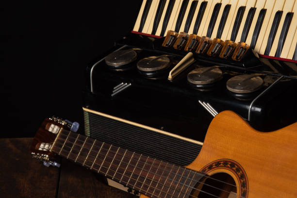 istock Old accordion and a beautiful guitar composing a scene on a rustic wooden surface with black background and low key lighting, selective focus. 1271180537