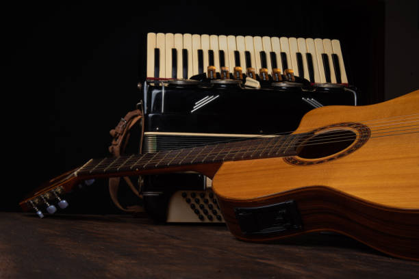 istock Old accordion and a beautiful guitar composing a scene on a rustic wooden surface with black background and low key lighting, selective focus. 1271180541