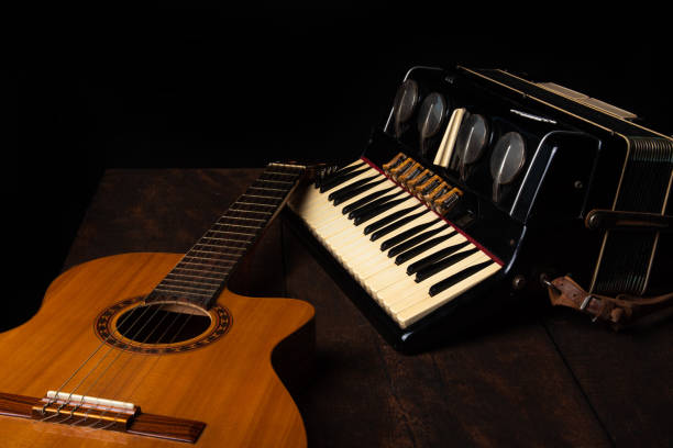 istock Old accordion and a beautiful guitar composing a scene on a rustic wooden surface with black background and low key lighting, selective focus. 1271180559