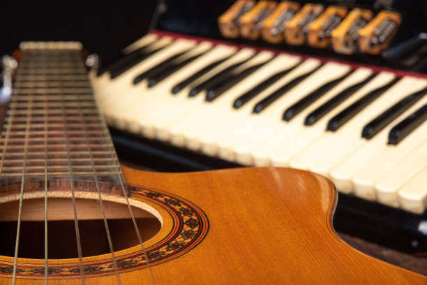 istock Old accordion and a beautiful guitar composing a scene on a rustic wooden surface with black background and low key lighting, selective focus. 1271180584