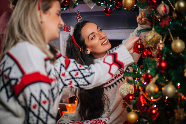 istock Female Friends Decorating Christmas Tree 1271181199