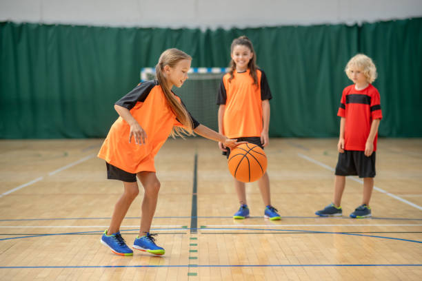 istock A girl playing with a ball and looking involved while friends waiting 1271183646