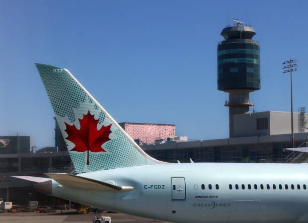 nahaufnahme des schwanzes von air canada jet mit ahornblatt-logo mit turm hinter - close to close up leaf tail stock-fotos und bilder