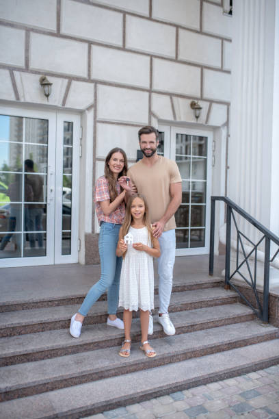 istock Young family standing on the steps and smiling 1271187685