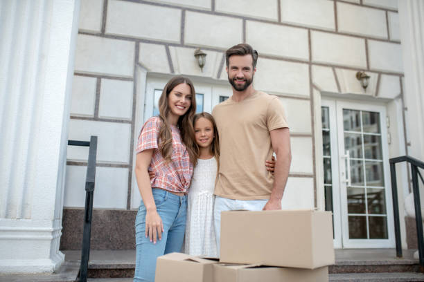 istock Young family standing near boxes and smiling 1271187713