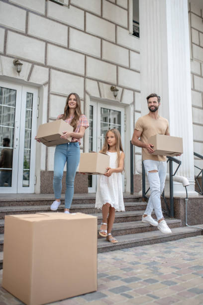 istock Young family carrying cardboards while getting ready to move 1271187720