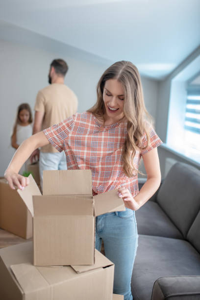 istock Young woman unpacking boxes and looking excited 1271188423