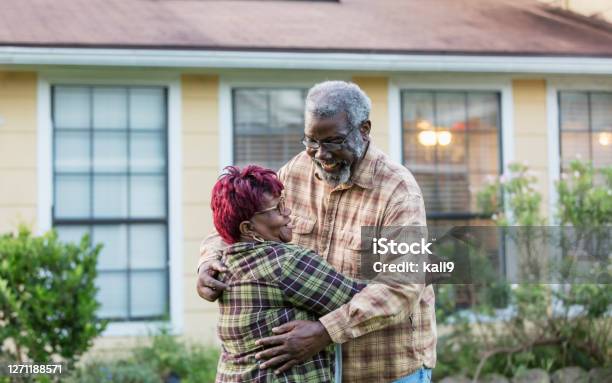 Senior Africanamerican Couple Hugging In Front Of Home Stock Photo - Download Image Now