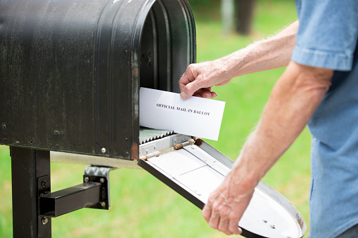 Senior man at rural mailbox.  He is getting his mail-in ballot for the upcoming election.