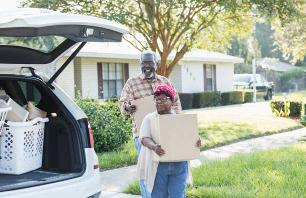 pareja afroamericana sénior moviéndose, cargando cajas - moving house physical activity moving van box fotografías e imágenes de stock