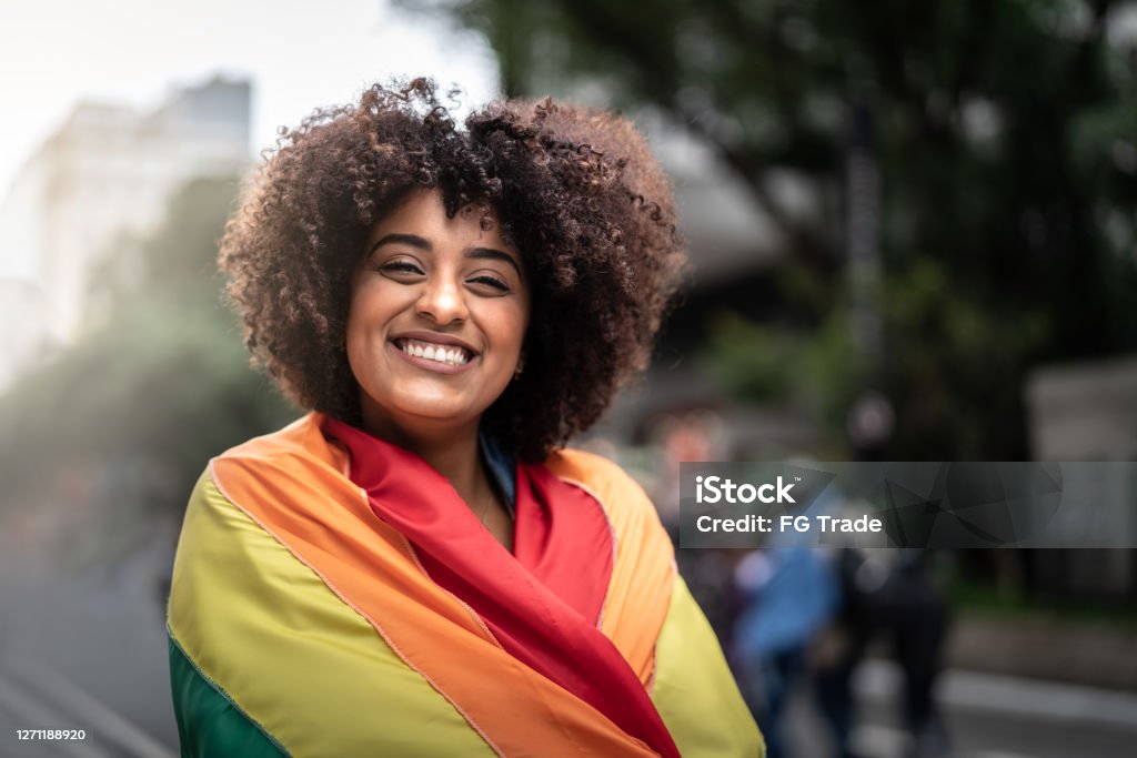Portrait of a happy woman wearing the rainbow flag LGBTQIA Pride Event Stock Photo