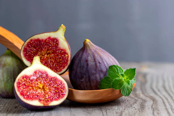 istock Fresh figs on the wooden table with mint leaves. 1271190158