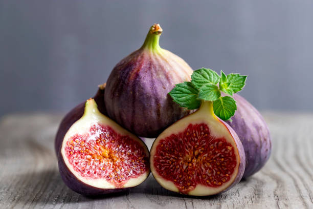 istock Fresh figs on the wooden table with mint leaves. 1271190837