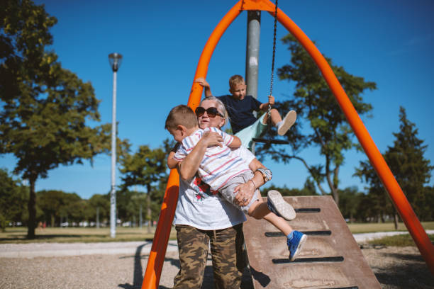 istock Children having fun with grandmother at the park 1271190865