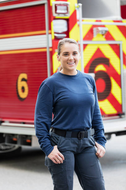 istock Female firefighter standing in front of fire truck 1271191174
