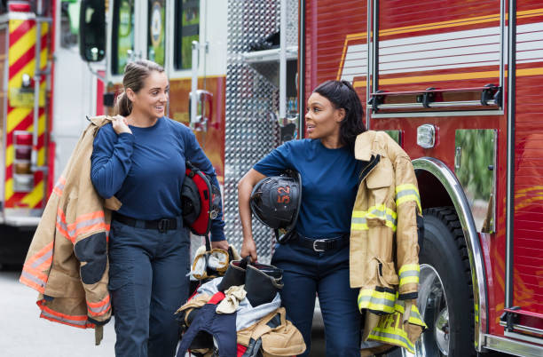 istock Two female firefighters walking next to fire trucks 1271191646