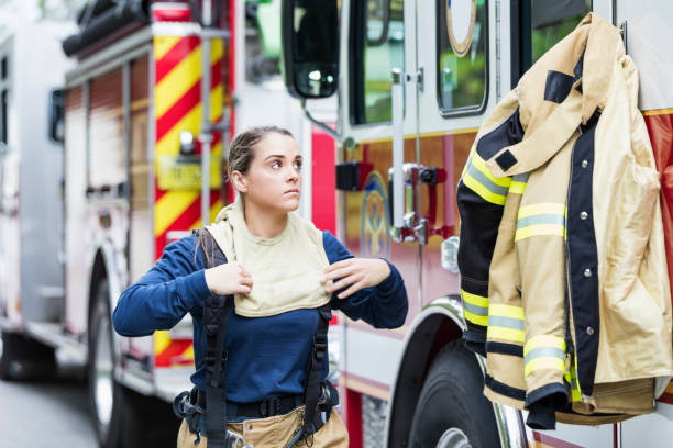 istock Female firefighter putting on protective suit 1271192269