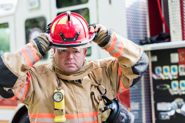 istock Firefighter in fire protection suit putting on helmet 1271192652