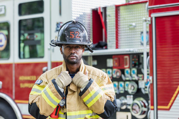 firefighter wearing protective gear - bombeiro imagens e fotografias de stock