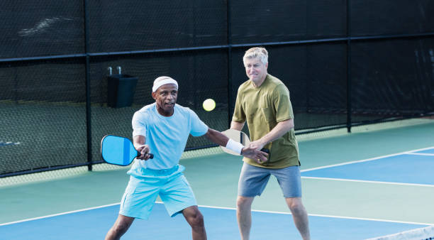 istock Senior men playing pickleball, hitting ball 1271193804