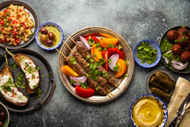 Middle eastern dinner table Delicious meat kebab with fresh vegetable salad served with variety of Middle eastern dishes and appetizers. Top view of assorted Arab food and meze, tasty and healthy Mediterranean cuisine middle eastern food photos stock pictures, royalty-free photos & images