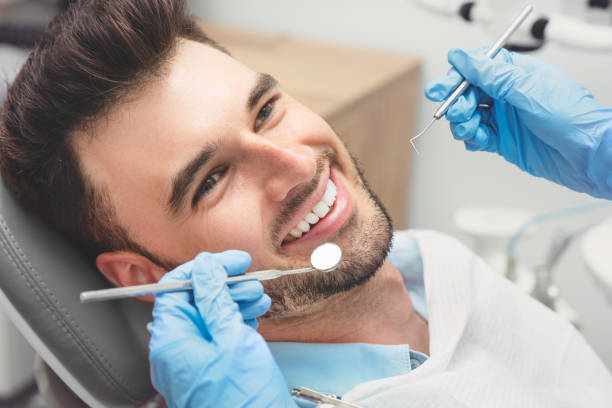 mann, der zähne bei zahnärzten untersuchen hat - zahnarzt stock-fotos und bilder